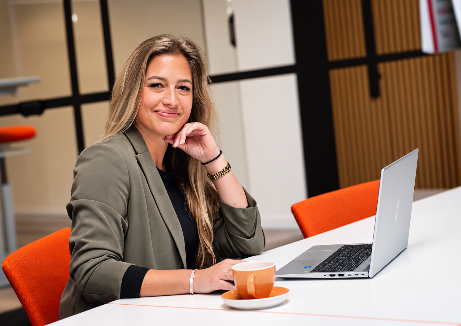 Recruiters bureau met opengeslagen sollicitatiemappen in een boog, voorzien van gekleurde sticky notes, zachte raamlicht en laptop op achtergrond.